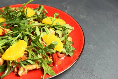 Kırmızı tabakta servis edilen lezzetli karışık sebze ve meyve salatası. Sağlıklı beslenme konsepti, taze sebze salatası.