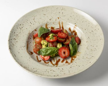 Çilekli salata. Mozzarella, domates, fesleğen ve çilekli salata. Beyaz arka planda. Sağlıklı yeme kavramı.