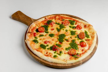 Kiraz domatesli ve fesleğen soslu pizza, beyaz arka planda kırsal taze pizza. Geleneksel İtalyan mutfağı kavramı.