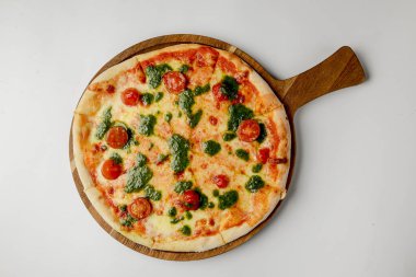 Kiraz domatesli ve fesleğen soslu pizza, beyaz arka planda kırsal taze pizza. Geleneksel İtalyan mutfağı kavramı.