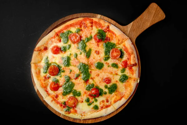 Kiraz domatesli ve fesleğen soslu pizza, siyah arka planda kırsal taze pizza. Geleneksel İtalyan mutfağı kavramı.