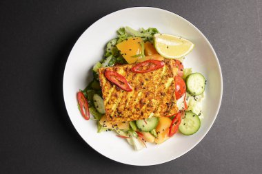 Izgara tavuklu sandviç ve tabakta taze sebze salatası, öğle yemeği ya da kahvaltı. Sağlıklı beslenme konsepti. Siyah arkaplanda servis edildi.