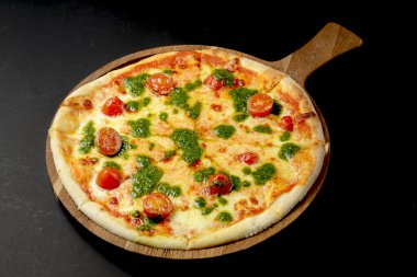 Kiraz domatesli ve fesleğen soslu pizza, siyah arka planda kırsal taze pizza. Geleneksel İtalyan mutfağı kavramı.