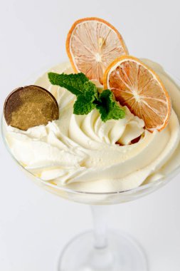 Büyük bardakta limonlu tiramisu bir parça çikolata ve beyaz arka planda kurutulmuş portakal dilimleri ile servis edilir. İtalyan mutfağı konsepti, geleneksel meyve tarifi.