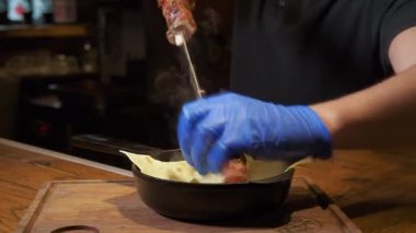 Tabakta kızarmış şiş kebap yakın çekim. Masada leziz bir barbekü. İçeride, mutfakta çalışan bir şef, çalışma süreci. Restoran kompleksi.