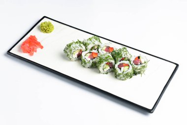 Ton balıklı suşi, salatalık ve doğranmış dereotlu krem peynirli sandviç. Beyaz arka planda beyaz bir tabakta servis edilmiş. Geleneksel Japon mutfağı konsepti, suşi tarifi.