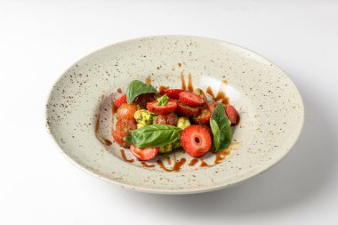 Çilekli Caprese salatası. Mozzarella, domates, fesleğen ve çilekli salata. Beyaz arka planda. Sağlıklı beslenme konsepti. İtalyan mutfağı.