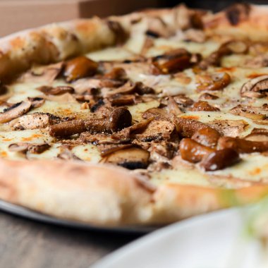 Ahşap arka planda mantarlı pizza. Lezzetli vejetaryen pizza yakından seçici odaklanma. Geleneksel tarif, İtalyan mutfağı konsepti. Pizza teslimat kutusu, teslimat konsepti..