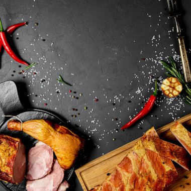 Siyah taş masada baharatlı ve şifalı domuz eti. Sancak biçimi, uzay web tasarım afişini kopyala. Kırmızı biber ve etli diğer baharatlar..