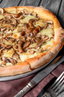 Kırsal ahşap arka planda mantarlı pizza. Lezzetli vejetaryen pizza. Geleneksel tarif, İtalyan mutfağı konsepti.