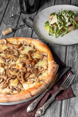 Kırsal ahşap arka planda mantarlı pizza. Lezzetli vejetaryen pizza. Geleneksel tarif, İtalyan mutfağı konsepti.