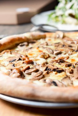 Kırsal ahşap arka planda mantarlı pizza. Lezzetli vejetaryen pizza. Geleneksel tarif, İtalyan mutfağı konsepti.