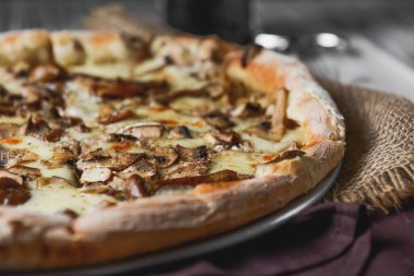 Kırsal ahşap arka planda mantarlı pizza. Lezzetli vejetaryen pizza. Geleneksel tarif, İtalyan mutfağı konsepti.