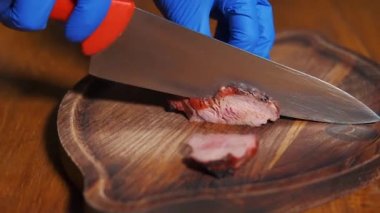 Köy ahşap masada servis edilen bir kasede domatesli ve peynirli biftek salatası. Yemek pişirme, salata için et kesme. Gürcistan mutfağı kavramı.