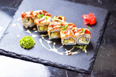 Suşi, sahanda yumurta, salatalık, krem peynir, sos. Suşi menüsü. Japon yemeği. Yakın çekim, seçici odaklanma, bulanık bir arka plan. Geleneksel tarif.