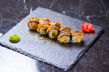 Maki Futomaki suşi rulosu, yılan balığı, yumurta, unagi sosu. Suşi menüsü. Japon yemeği. Yakın çekim, seçici odaklanma, bulanık bir arka plan. Geleneksel tarif.