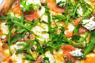 Mozarellalı pizza, somon dilimleri, taze roka. Pizza çok yakın, pizza desenli. İtalyan mutfağı, geleneksel pizza tarifi..