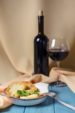 Bej bez arka planda beyaz bir kasede servis edilen soslu ve tostlu fırında camembert peyniri. Kırmızı şarapla servis edilir. Lezzetli yemek fikri, Fransız mutfağı konsepti, geleneksel tarif..