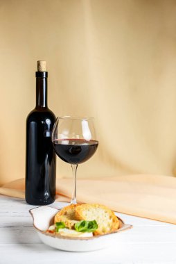 Bej bez arka planda beyaz bir kasede servis edilen soslu ve tostlu fırında camembert peyniri. Kırmızı şarapla servis edilir. Lezzetli yemek fikri, Fransız mutfağı konsepti, geleneksel tarif..