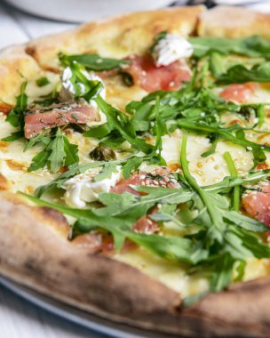 Mozarellalı pizza, somon dilimleri, taze roka. Beyaz arka planda izole edilmiş. İtalyan mutfağı, geleneksel pizza tarifi..