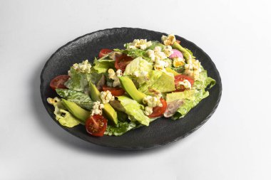 Bir tabak taze ve sağlıklı yaz avokadosu ve taze yeşillik ve patlamış mısırlı domates salatası. İtalyan mutfağı konsepti, sağlıklı yemek. Kapatın. Yaz menüsü.