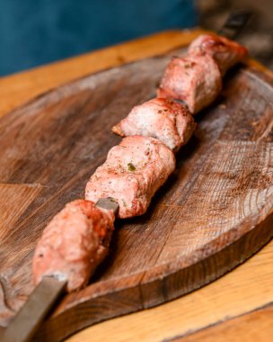 Salamura edilmiş şiş kömürün üstünde ızgarada pişirilmiş. Şiş kebap, Şiş kebap, Şiş kebap restorandaki tahta bir tahtanın üzerinde. Bulanık arkaplan.