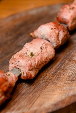 Salamura edilmiş şiş kömürün üstünde ızgarada pişirilmiş. Şiş kebap, Şiş kebap, Şiş kebap restorandaki tahta bir tahtanın üzerinde. Bulanık arkaplan.
