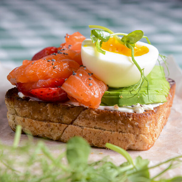 Smorrebrod, traditional Danish open sanwiches, dark rye bread with different toppings. Salmon, avocado, egg sandwich.