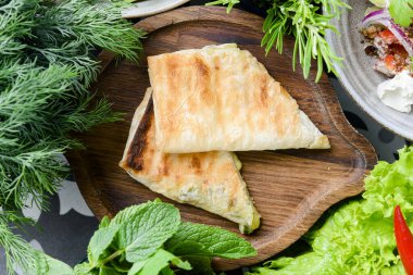 Ev yapımı lahanalı sandviç, sebzeli, ıspanaklı ve marullu ahşap arka planda. Geleneksel Gürcü mutfağı konsepti, akşam yemeği.