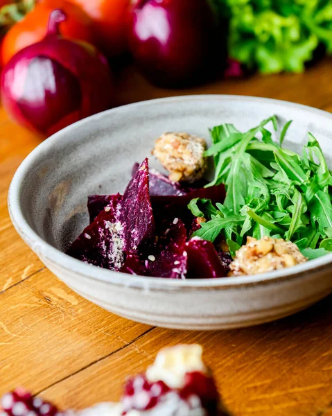 Rendelenmiş pancar salatası ve kırsal ahşap arka planda bir kasede bir sürü taze yeşillik bulunan otlar. Gürcistan mutfağı konsepti, Gürcistan geleneksel menüsü.