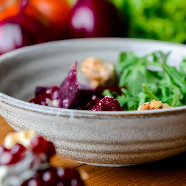 Rendelenmiş pancar salatası ve kırsal ahşap arka planda bir kasede bir sürü taze yeşillik bulunan otlar. Gürcistan mutfağı konsepti, Gürcistan geleneksel menüsü.