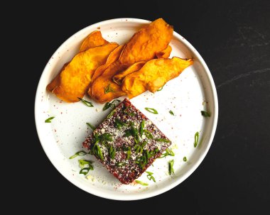 Domateslerden yapılmış taze sebze salatası, kabak, taze soğan ve sos beyaz tabakta servis edilir, koyu arkaplan. Siyah, akşam yemeği fikri..