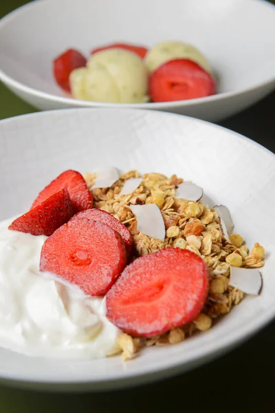 Bir kase taze çilekli sıcak yulaf ezmesi. Sağlıklı bir kahvaltı kadar mükemmel. Beyaz kasede ekşi kremayla servis ediliyor. Kahvaltı konsepti.