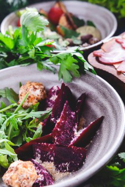 Rendelenmiş pancar salatası ve kırsal ahşap arka planda bir kasede bir sürü taze yeşillik bulunan otlar. Gürcistan mutfağı konsepti, Gürcistan geleneksel menüsü.