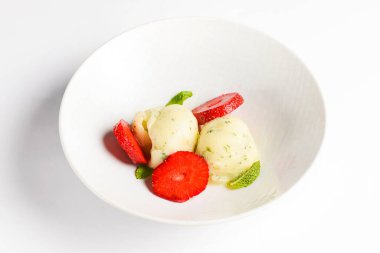 Çilekli, taze ve beyaz bir kasede dondurmayla kesilmiş. Lokantada ya da kafede servis edilen lezzetli soğuk yaz tatlıları..