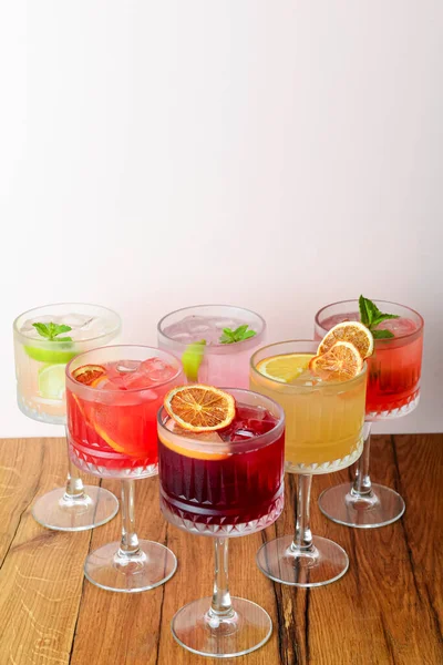 The concept of Georgian cuisine. Cool drink with ice made of fruit juice in a glass goblet with orange slice. Served on a rustic wooden table.