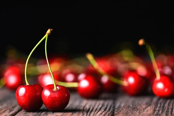 Seasonal fresh cherry fruit over rustic wooden background. Cherry texture, banner. Summer concept, fresh red cherry in rustic style. Close up, selective focus.