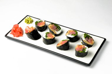 Beyaz arka planda beyaz bir tabakta servis edilen pirinçsiz suşi. Beyazda izole edilmiş. Wasabi soslu ve zencefilli. Japon mutfağı konsepti, diyet.