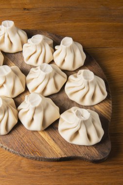 Ulusal Gürcü mutfağı. Etli Khinkali. Khinkali ahşap bir tahtanın üzerinde, yakın plan. Kırsal biçim