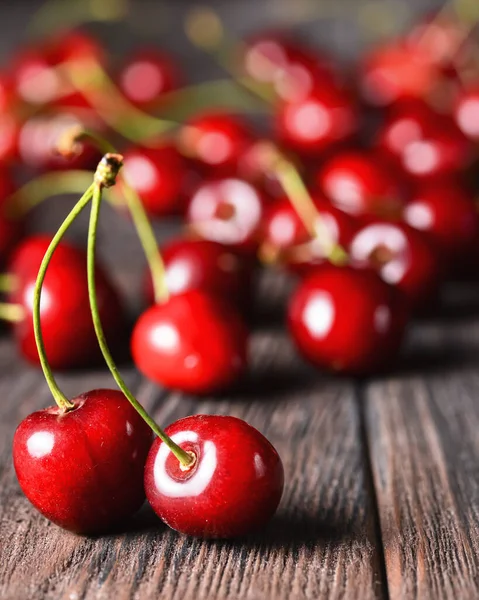 Seasonal fresh cherry fruit over rustic wooden background. Cherry texture, banner. Summer concept, fresh red cherry in rustic style. Close up, selective focus.