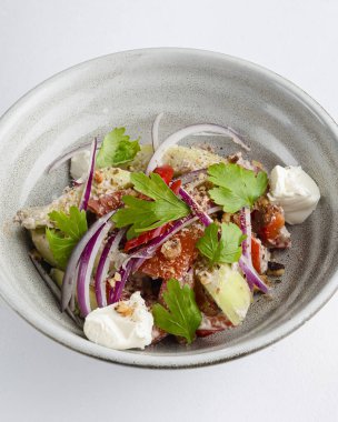 Domatesli salata, peynir ve tatlı ve ekşi soslu kişniş. Gürcistan mutfağı. Sağlıklı yiyecekler. Kırsal ahşap masada diğer tabaklarla birlikte bir kasede servis edilmiş..