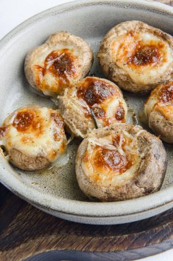 Geleneksel Gürcistan yemeği doldurulmuş mantarlar beyaz arka planda bir kase dolusu taze yeşillikle servis edilir. Peynirli mantarlar..