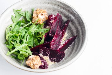 Rendelenmiş pancar salatası ve beyaz arka planda bir kasede taze yeşillik içeren otlar. Gürcistan mutfağı konsepti, Gürcistan geleneksel menüsü.