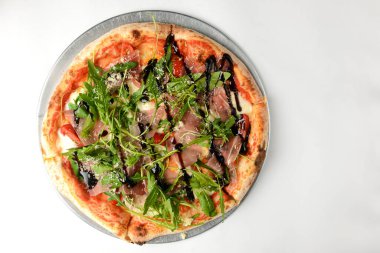 Beyaz arka planda taze roka ve prosciutto ile ev yapımı pizza. Beyazda izole edilmiş. Boşluk afişini kopyala.