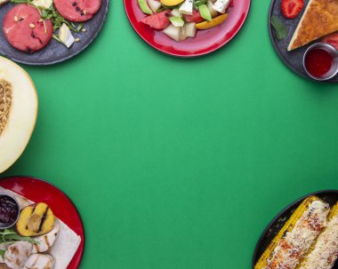 Yemek arkaplanı. Malzemeler, karpuzlu yaz yemekleri, kavun, şeftali ve avokado. Parlak yeşil arka planda. Uzay afişini kopyala, taze lezzetli yemekler.