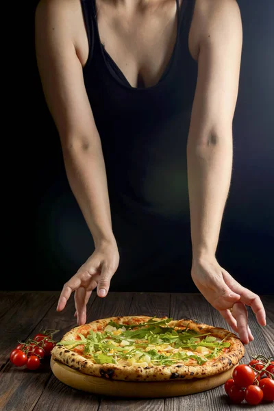 맛좋은 피자를 배경에 향신료와 야채와 넣었습니다 여성들은 피자를 손으로 잡습니다 — 스톡 사진