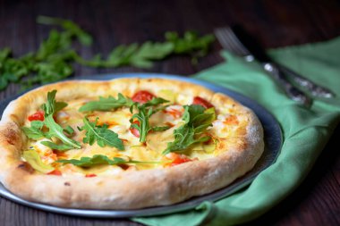 Peynirli ev yapımı pizza ve koyu ahşap arka planda servis edilen taze roka. Geleneksel pizza tarifi, İtalyan mutfağı kavramı.