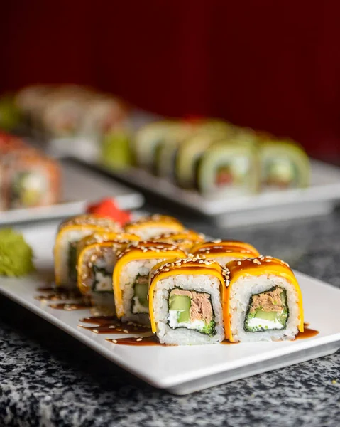 Philadelphia ya da California avokado ve krem peynirli suşi sarar. Peynirli suşi menüsü. Geleneksel Japon yemeği konsepti. Restoranda beyaz bir tabakta servis edilir, konsepti dışarıda yenir..