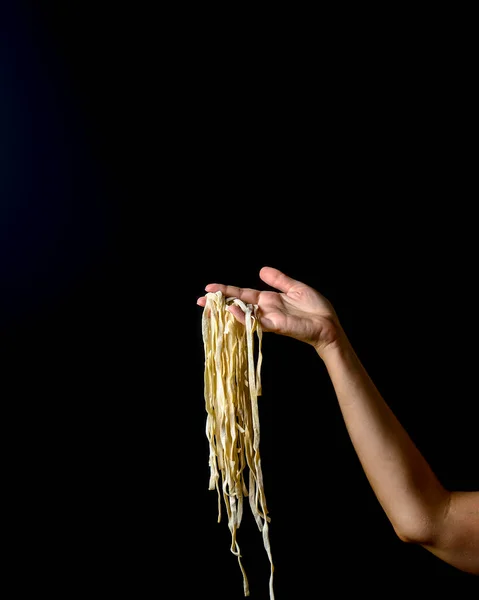 Mão Jogando Macarrão Ovo Fundo Escuro Voando Macarrão Cozido Mãos — Fotografia de Stock