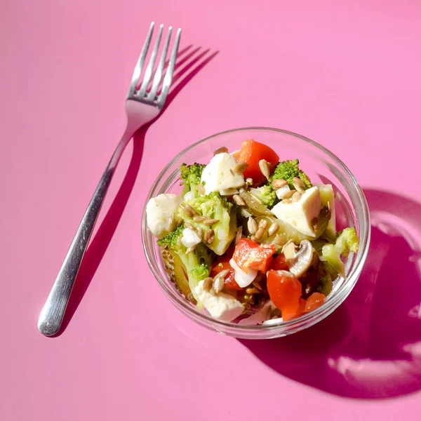 ブロッコリー トマト フェタサラダにキノコを添えて カラフルなピンクの背景の上に小さなボウルで提供しています 健康的な食事の概念 スペース垂直バナーのコピー — ストック写真